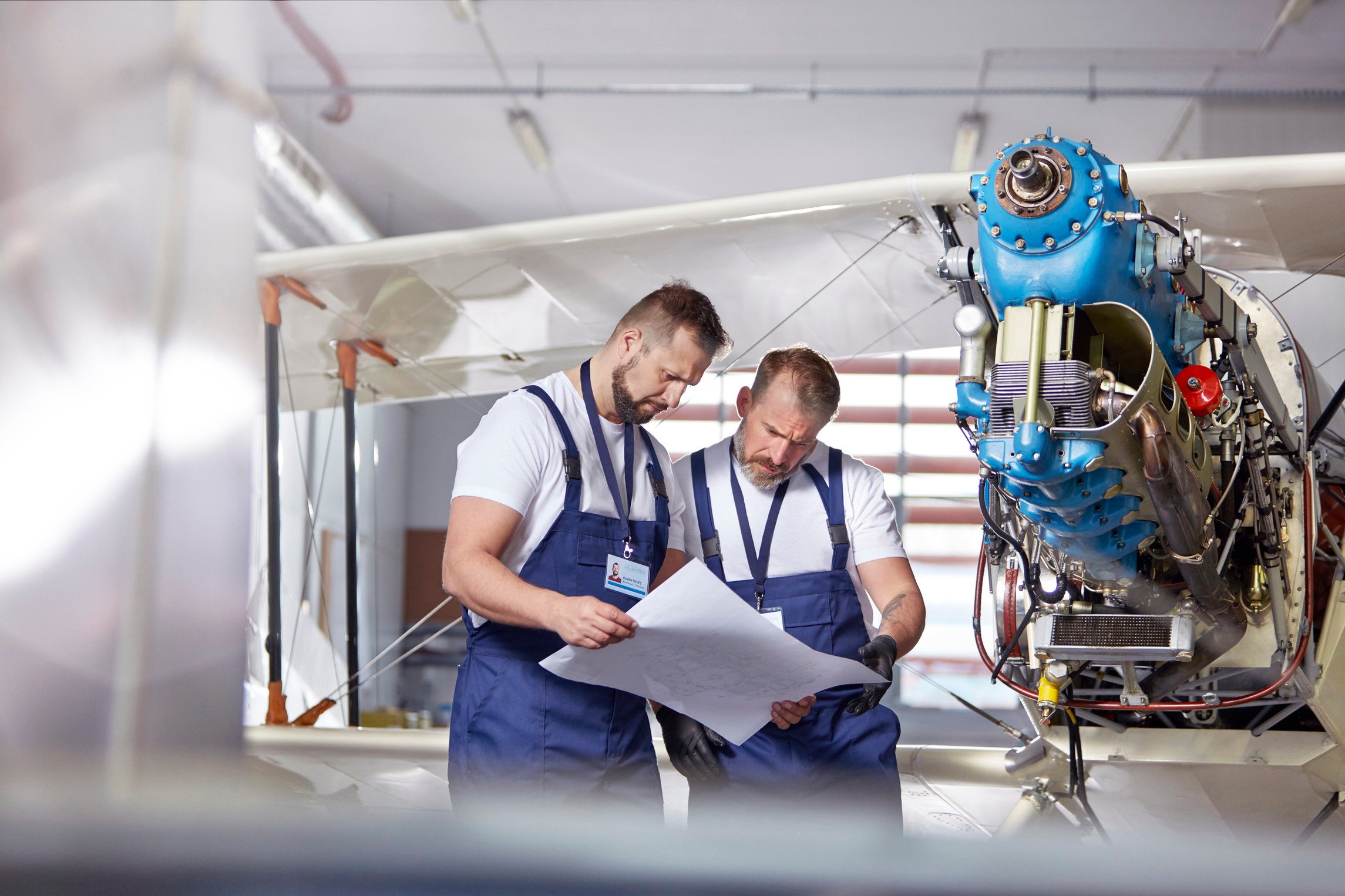 "Male engineer mechanics examining plans